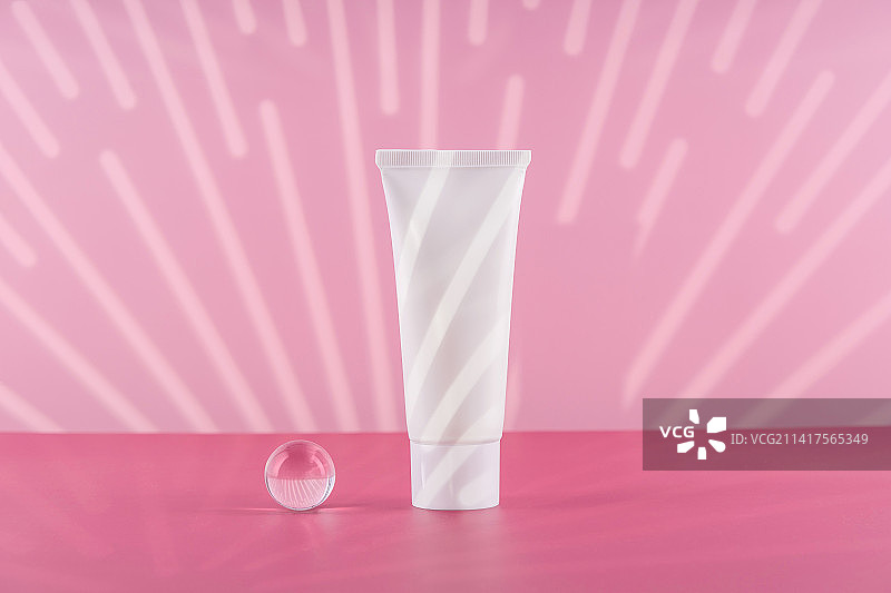 粉色背景上的无品牌化妆品白色塑料软管模型图片素材