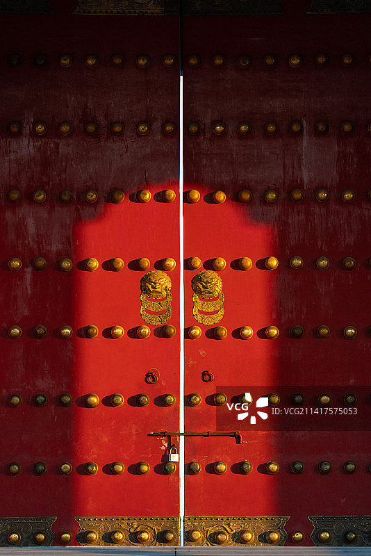 故宫日出时分阳光照在朱漆宫门上的光与影图片素材