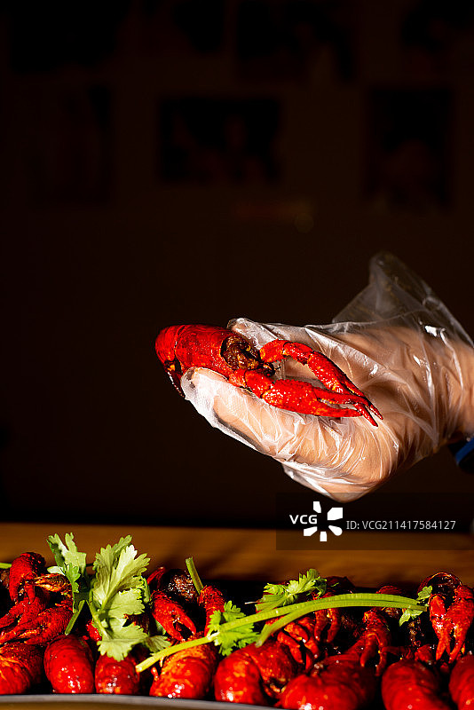夏季中国传统美食清蒸小龙虾手部特写图片素材