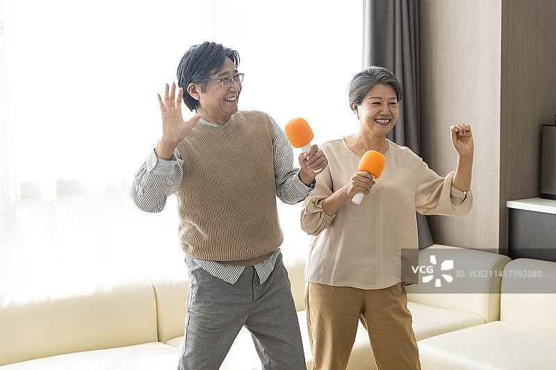 老年夫妻在客厅唱卡拉OK图片素材