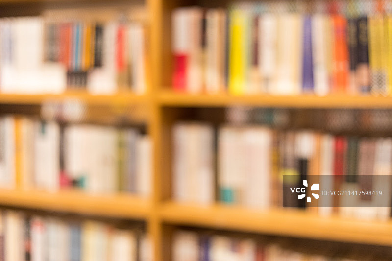 宽敞的图书馆里排列着整齐的书架虚焦图片素材
