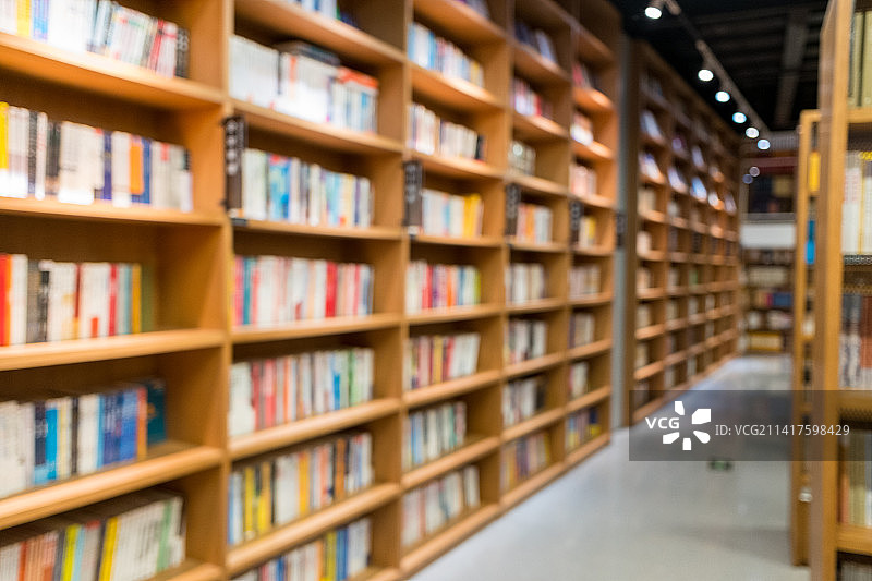 宽敞的图书馆里排列着整齐的书架虚焦图片素材