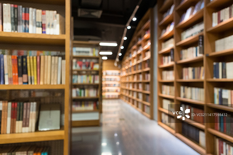 宽敞的图书馆里排列着整齐的书架虚焦图片素材