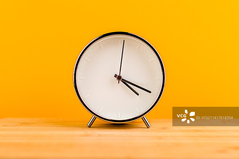黄色背景上的闹钟，时间概念图片素材