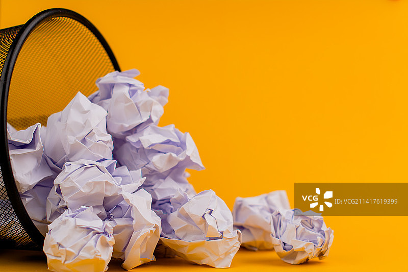 黄色背景垃圾桶里的白色废纸，废纸概念，泰国图片素材