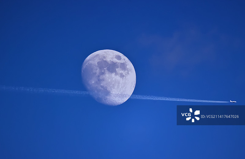 德国奥斯特菲尔登蓝天下飞机尾迹的仰视视角图片素材