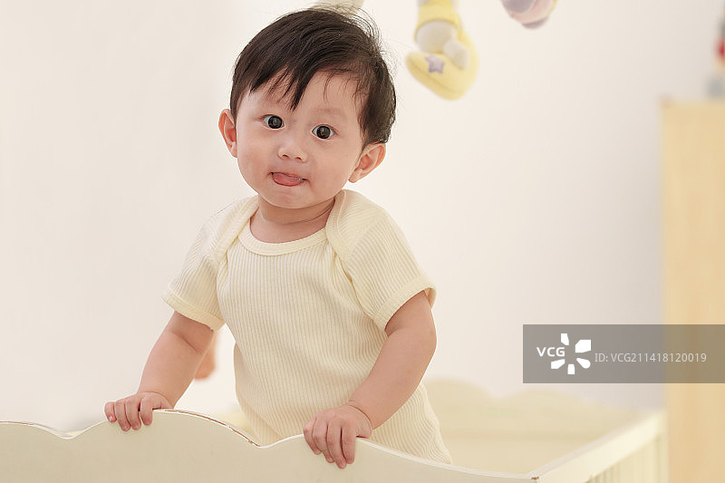 可爱宝宝在婴儿床上玩耍图片素材