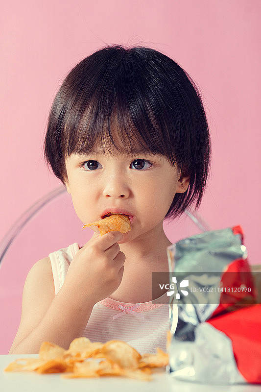 可爱的小男孩吃薯片图片素材