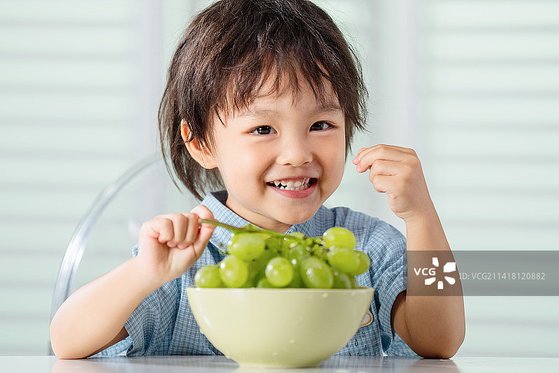 快乐的小男孩吃葡萄图片素材