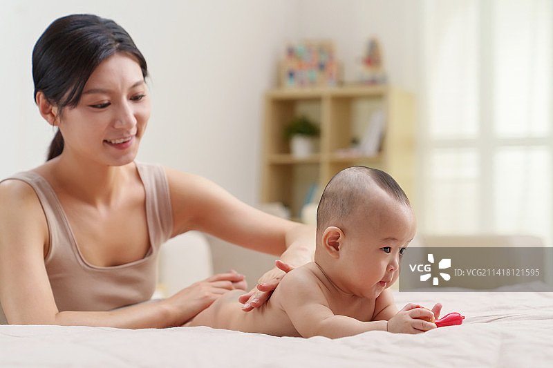 年轻妈妈给宝宝做按摩图片素材