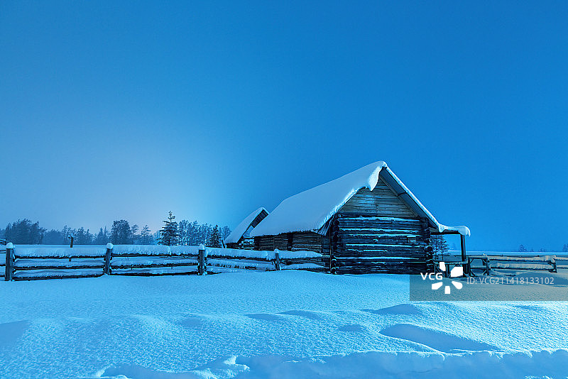 冬季新疆喀纳斯图瓦村雪地上的木屋夜景图片素材