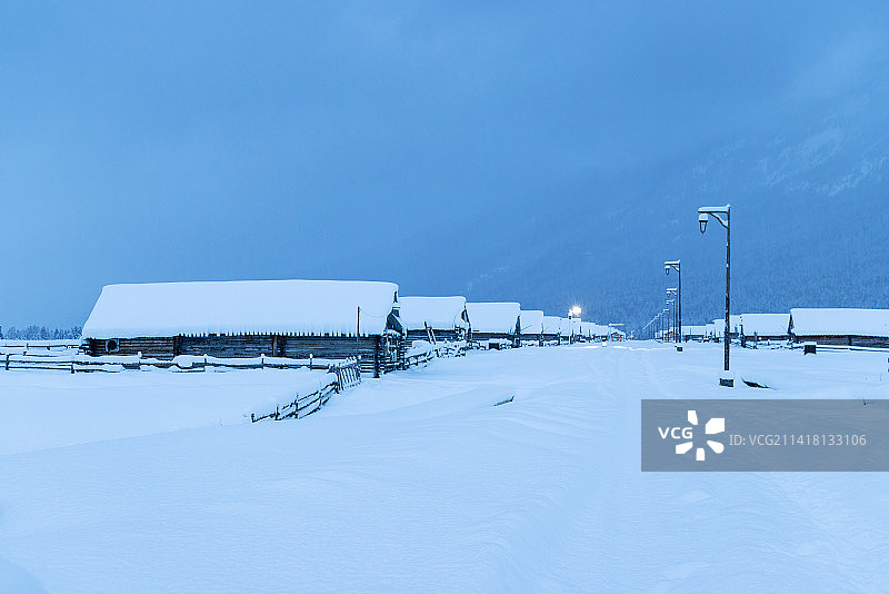 冬季新疆喀纳斯图瓦村雪地上的木屋夜景图片素材