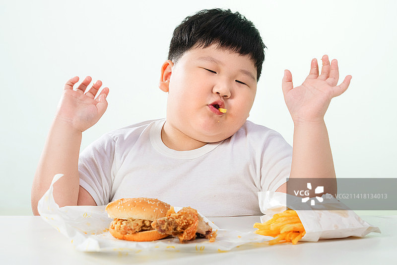 可爱的肥胖小男孩吃炸鸡汉堡图片素材