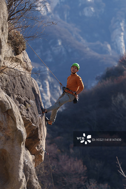 青年男人在悬崖峭壁上攀岩图片素材
