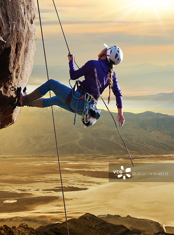 青年女人在悬崖峭壁上攀岩图片素材