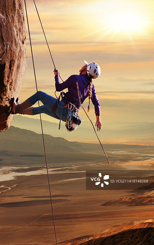 青年女人在悬崖峭壁上攀岩图片素材