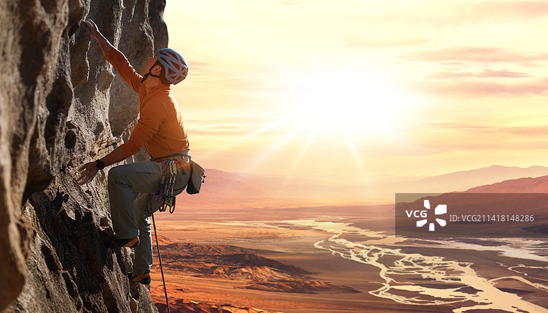 青年男人在悬崖峭壁上攀岩图片素材