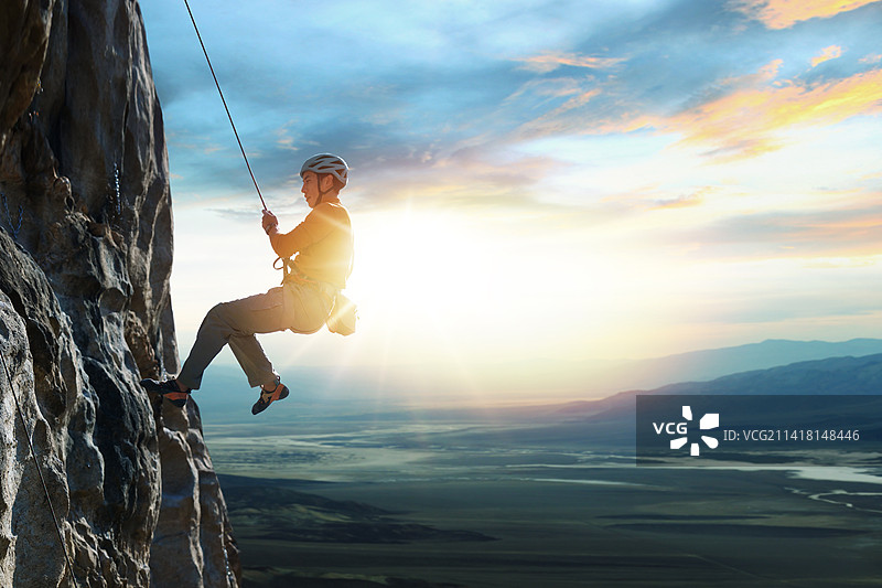 青年男人在悬崖峭壁上攀岩图片素材