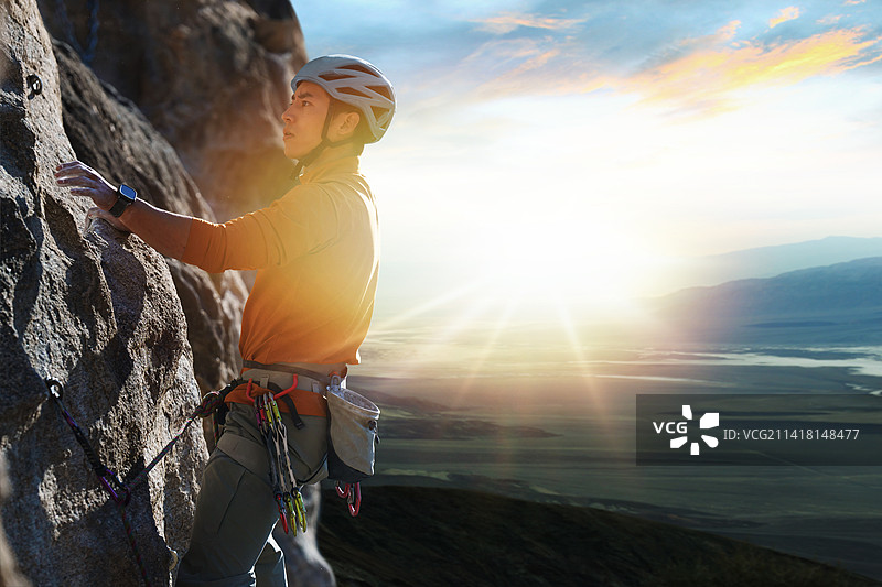 青年男人在悬崖峭壁上攀岩图片素材