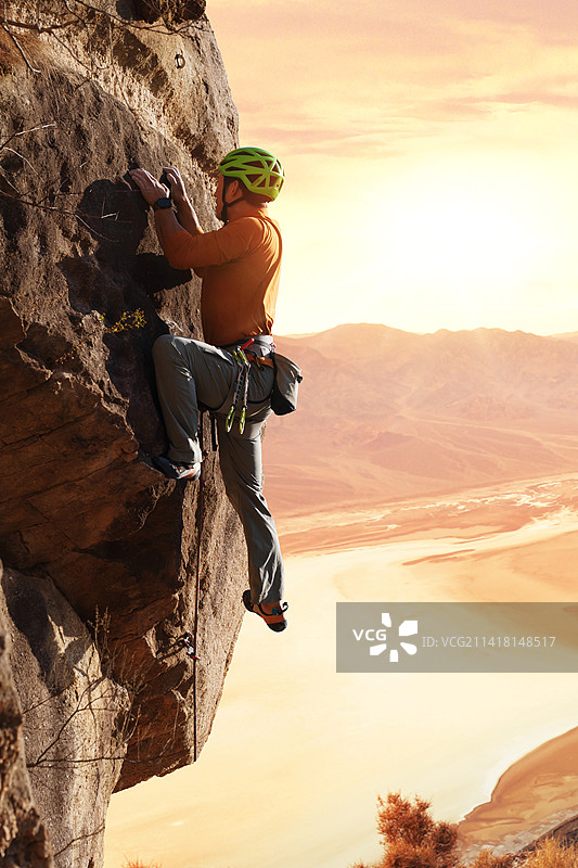 青年男人在悬崖峭壁上攀岩图片素材