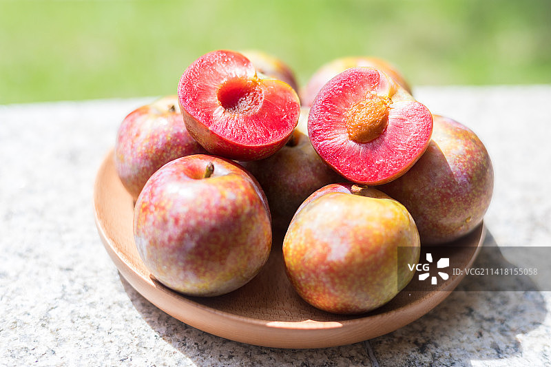 阳光下一碟新鲜的广东茂名钱排银妃三华李图片素材