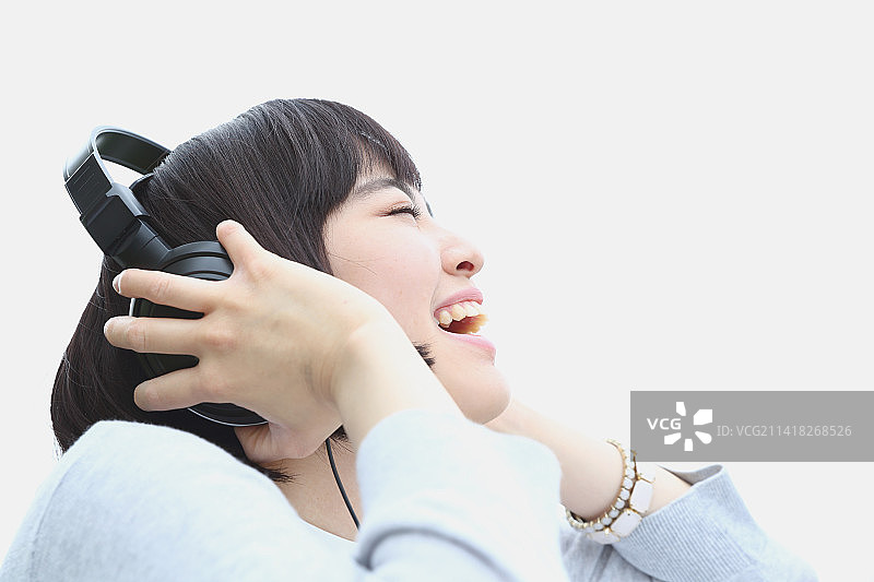 戴耳机听音乐的年轻日本女人图片素材