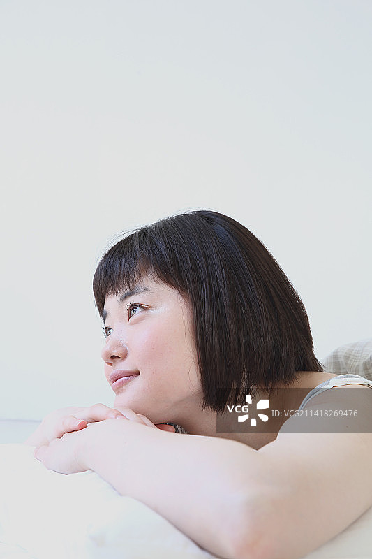 年轻的日本女人在床上放松图片素材