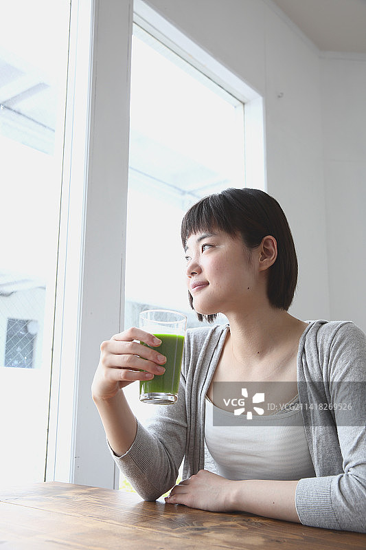 喝绿色冰沙的年轻日本女人图片素材