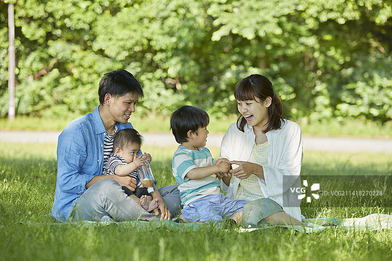 在草坪上放松的日本家庭图片素材