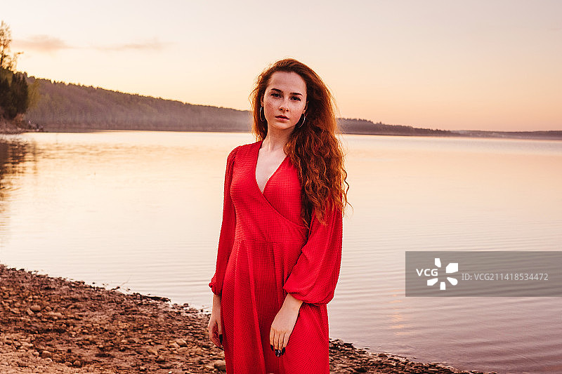 在俄罗斯日落时分穿红色连衣裙的年轻女人图片素材
