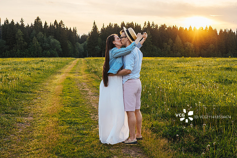 俄罗斯日落时分，田野里的情侣图片素材