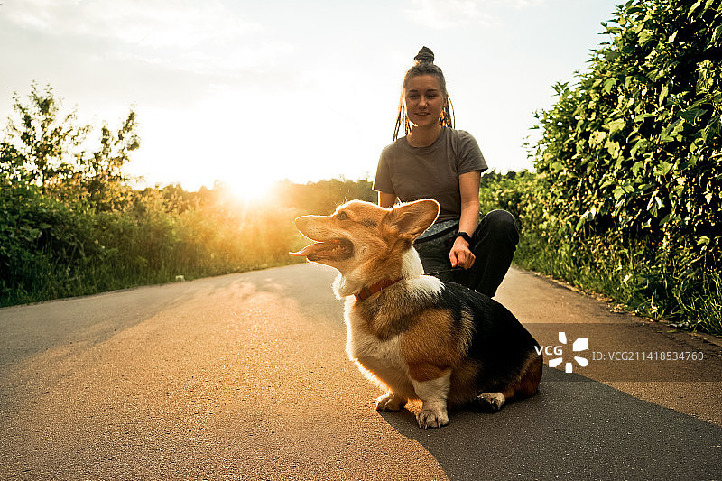 辫绳女人和柯基犬在俄罗斯散步图片素材