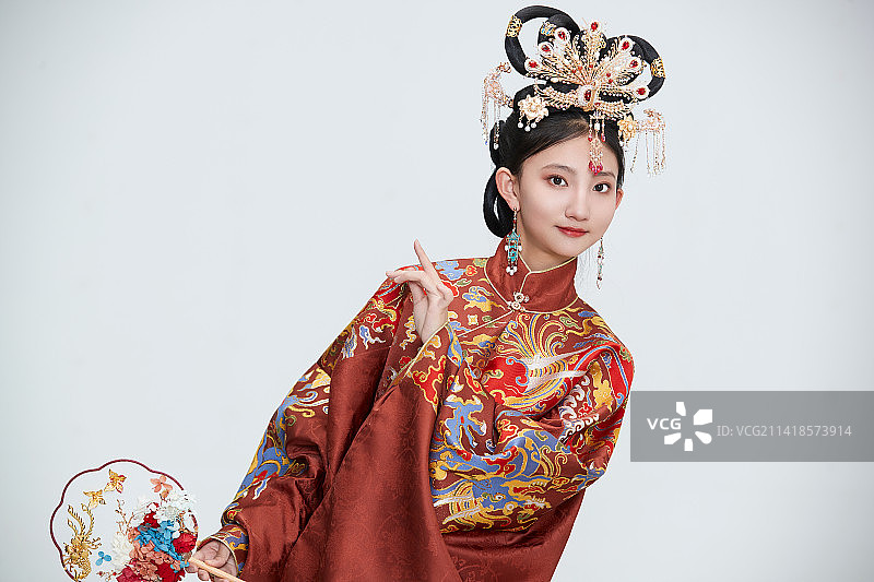 白色背景下穿着明代凤冠霞帔汉服的可爱少女图片素材