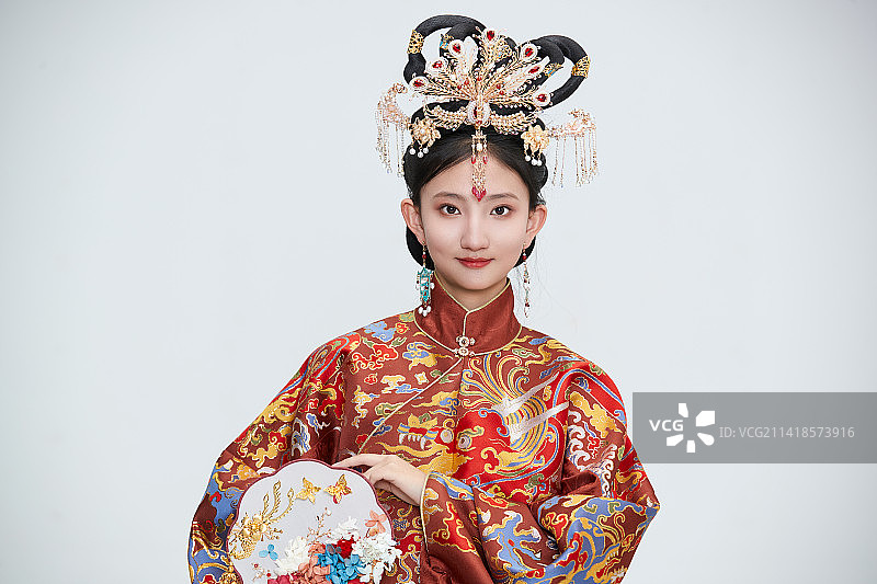 白色背景下穿着明代凤冠霞帔汉服的可爱少女图片素材