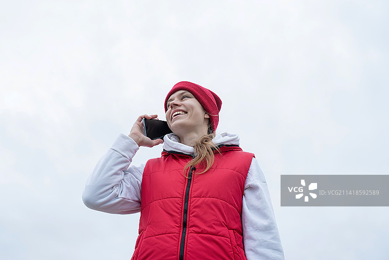 中国北京：腿部手术后佩戴护膝的妇女在公园里使用智能手机图片素材