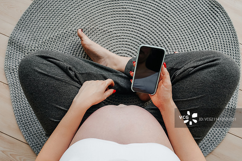 手里拿着手机的孕妇（俄罗斯，俯视角度）图片素材