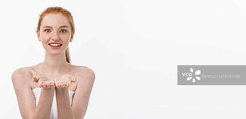 对着白色背景微笑的年轻女子的肖像图片素材