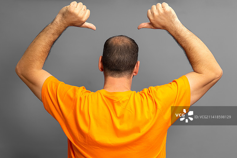 男子在灰色背景下展示肌肉的背影图片素材