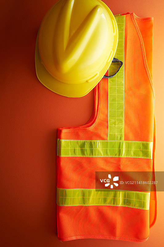 橙色背景下的反光背心和头盔，马来西亚图片素材