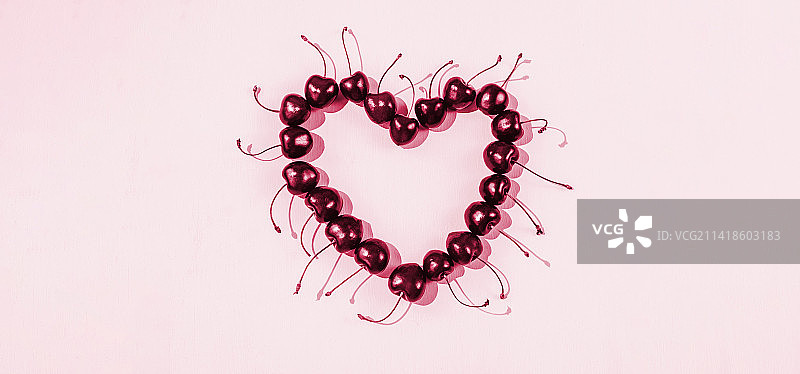 粉色背景上的甜樱桃心形图案（俄罗斯）图片素材