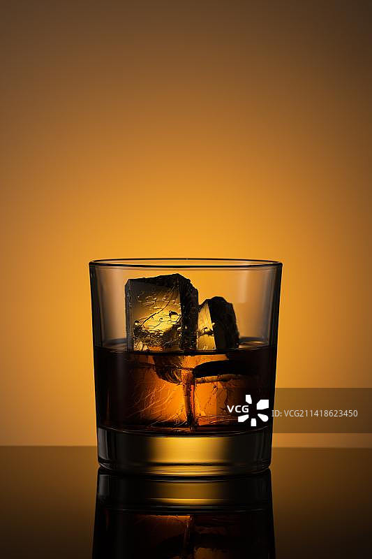 印度尼西亚勿加泗黑色背景下桌上玻璃杯中的威士忌特写图片素材