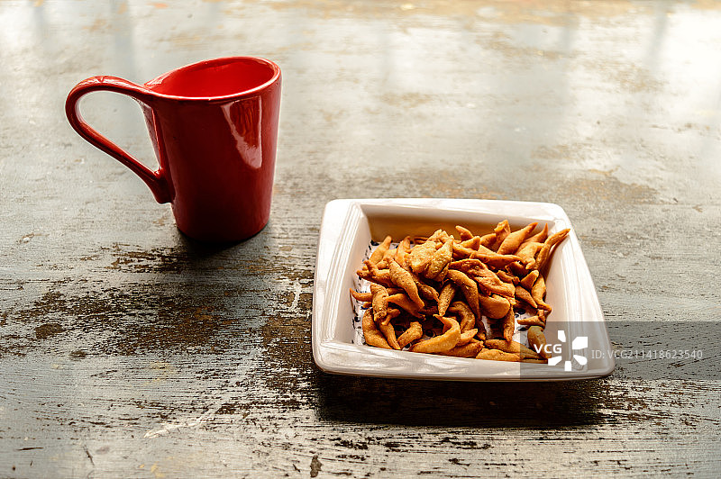 红色咖啡杯和一盘印度小吃特写图片素材