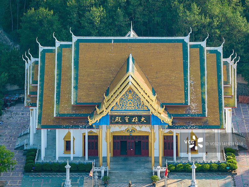 日出时分温暖的阳光洒向地面，鸟瞰报恩禅寺泰式风格的寺庙和放生池图片素材
