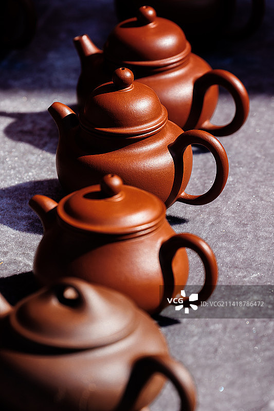 集市上阳光中的一排紫砂壶图片素材