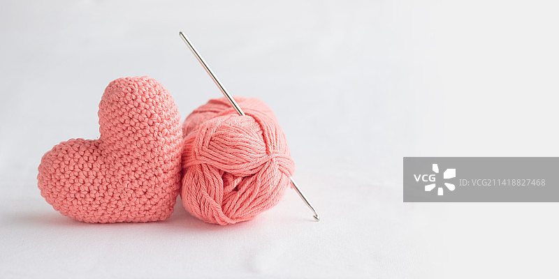 白色背景上的钩针粉色爱心与钩针和纱线，情人节，芬兰图片素材