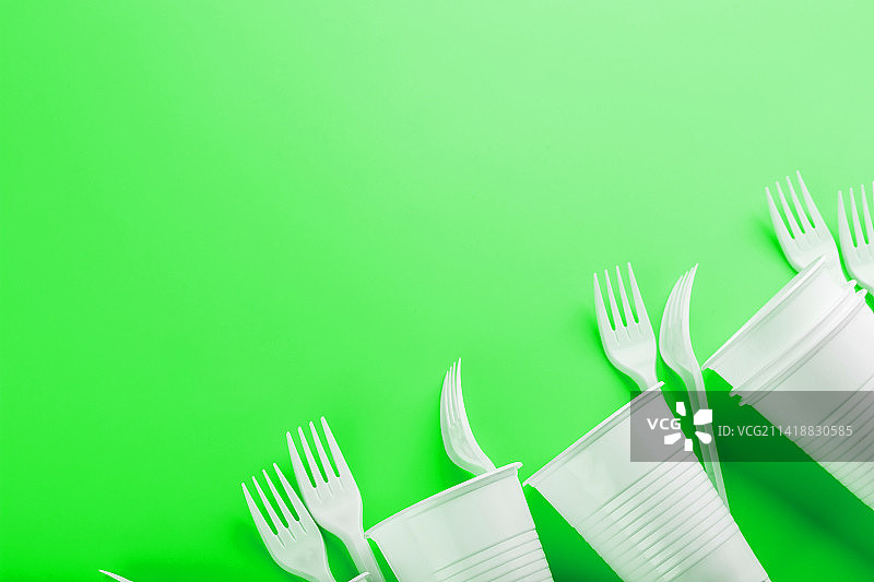 绿色背景上的塑料餐具图片素材