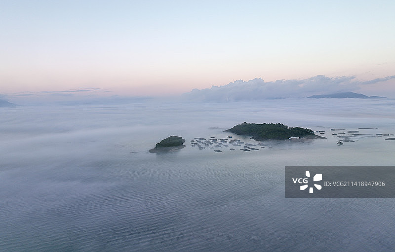 平流雾下的海上小岛和渔船图片素材