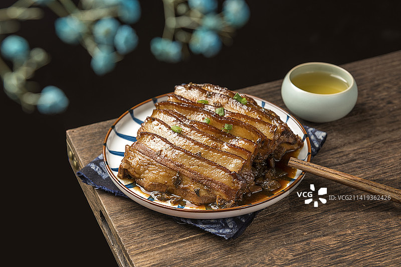 一盘梅菜扣肉摆放在木桌面上特写图片素材