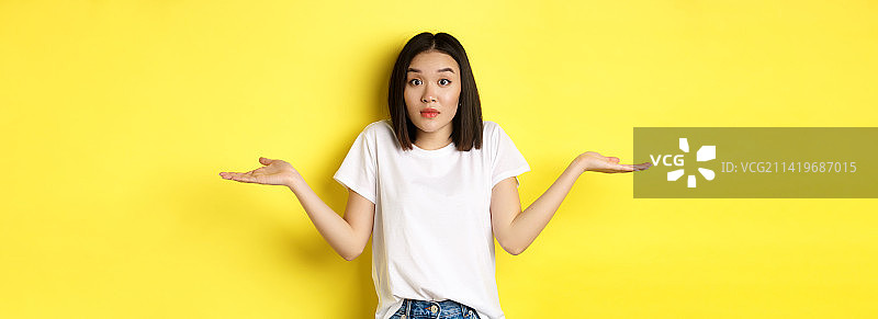 茫然的亚洲女孩耸肩，摊开双手图片素材
