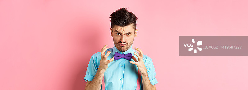 戴着领结，举起双手，要勒死某人的愤怒男子照片图片素材